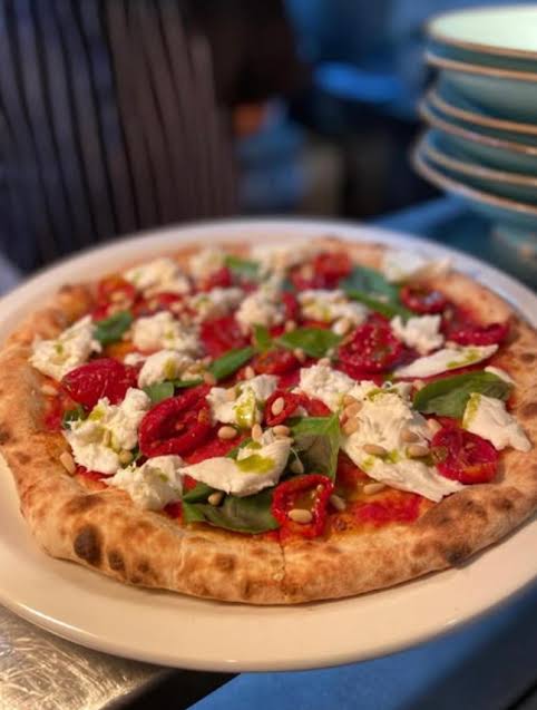 Wood-fired pizza with buffalo mozzarella, datterini tomatoes and basil